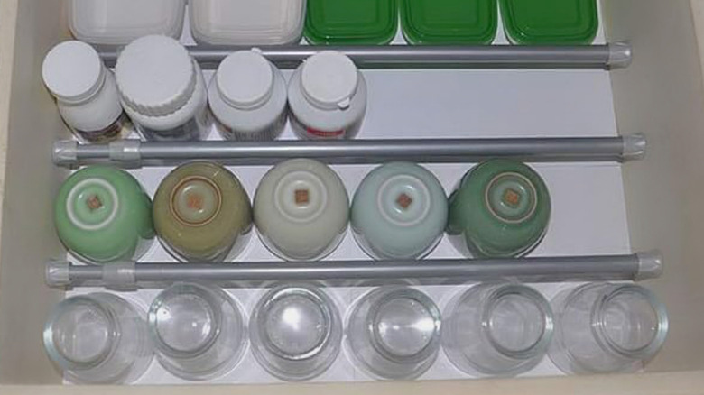 The KXLife Tension Curtain Rod hilding items in place in a drawer.