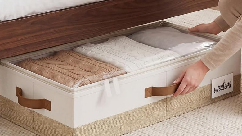 Sliding a StorageWorks Under-Bed Storage Container under a bed.