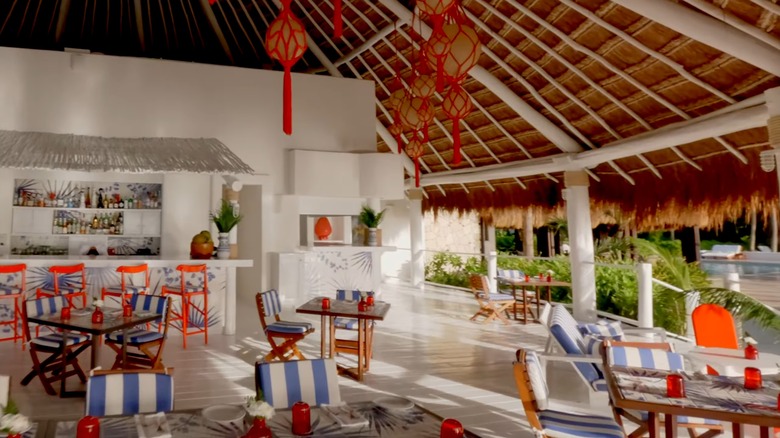 Tables, chairs, and a bar ready for service in an open-air resort dining area