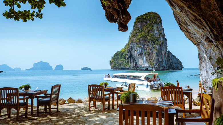 Restaurant with chairs on the beach in limestone cliff grotto