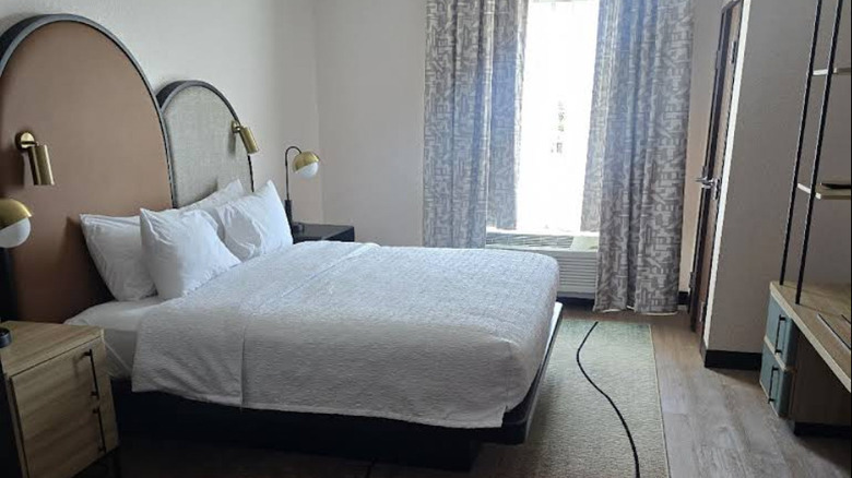 Interior view of modern, boutique-style hotel room in cream, black, and neutral palette at Hampton Inn Tampa Fairgrounds Casino
