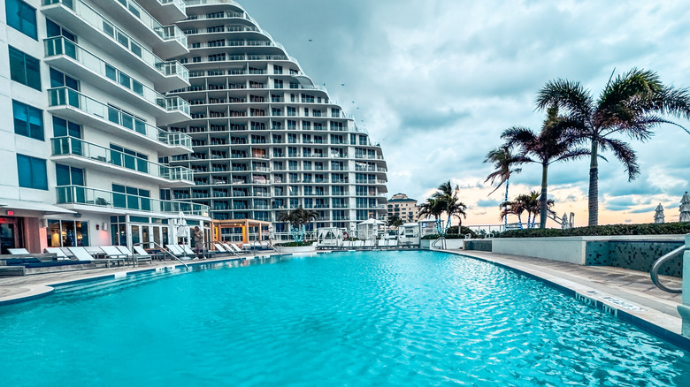 The pool and sundeck at the Hilton hotel and resort in Fort Lauderdale, Florida with palm trees swaying