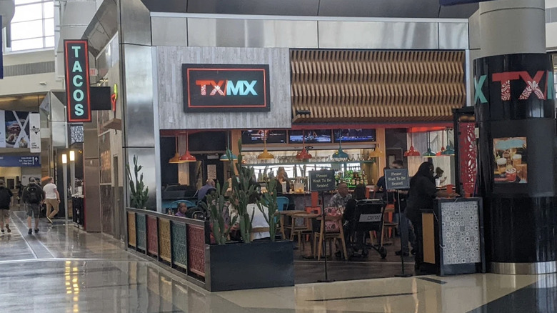 Exterior of TX/MX restaurant with colorful decor and cacti
