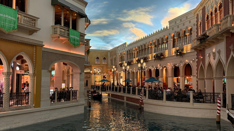 View of a Venetian canal with painted sky and people dining in "open air" piazzas at The Venetian Resort Las Vegas