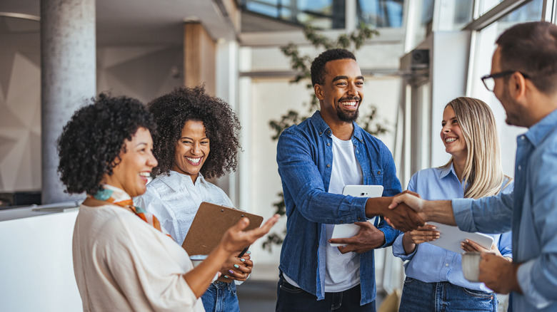 A diverse group of people smiling and talking together