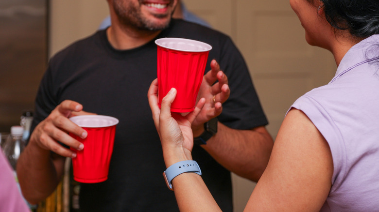 People holding red plastic cups at a party