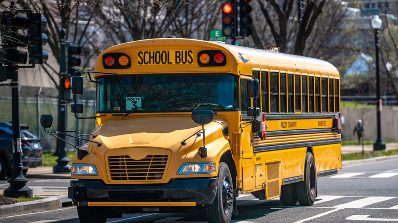 A yellow school bus driving down the street