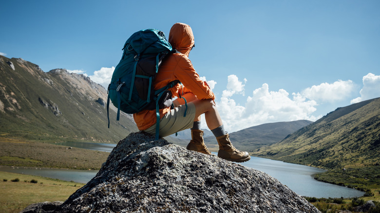 A hiker enjoying a lake view while resting.