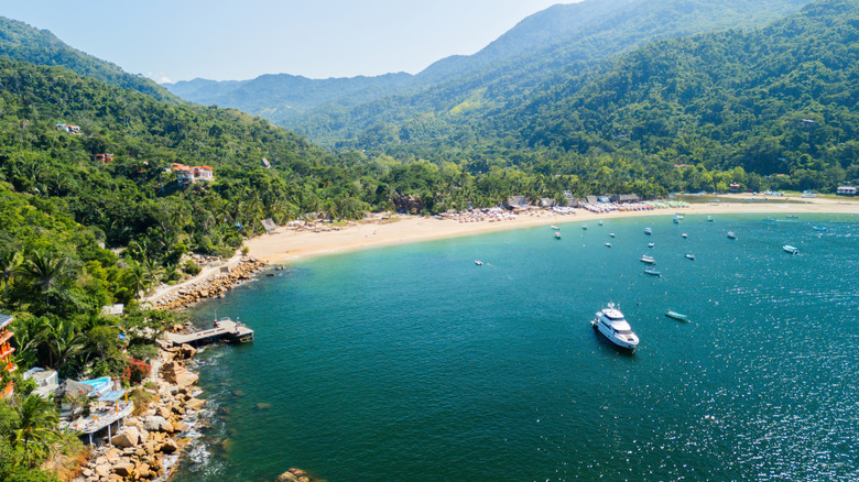 An aerial view of Yelapa's bay and Escondido Beach; steep mountainous slopes covered with green jungle rise up right behind the beach