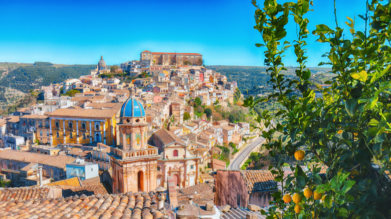View of Ragusa's historic center, tightly packed stone buildings surrounding a blue-domed church