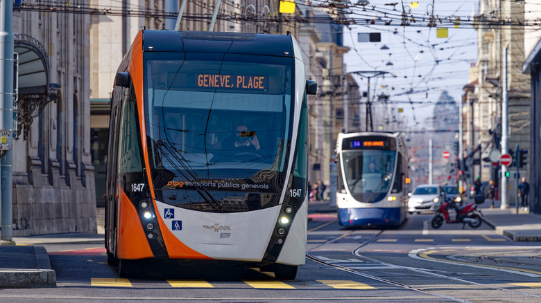 Crossroads with traffic and trolley bus and tram at Swiss City of Geneva on a sunny winter day.