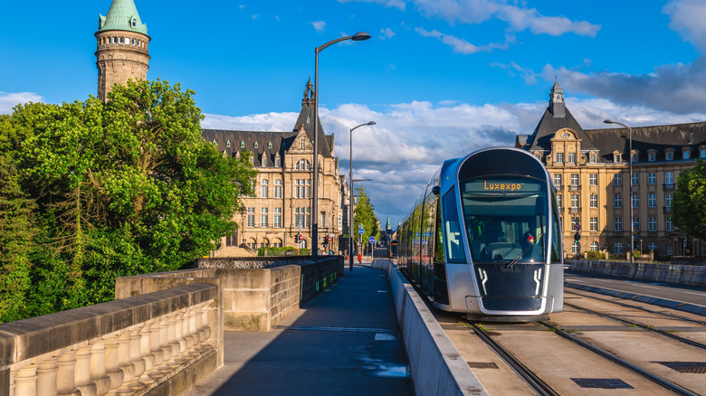 A tram crossing the Adolphe bridge in Luxembourg on a bright sunny day