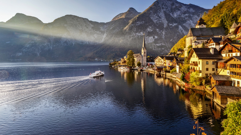 A boat steaming toward the coast of Salzburg in Austria, with mountains in the distance.