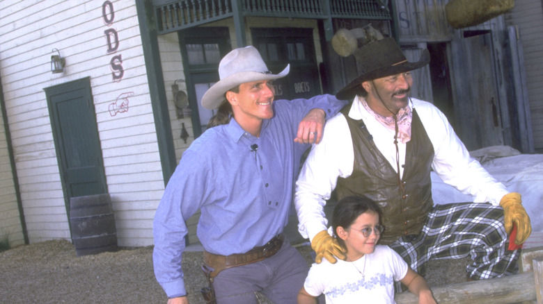 Performers in the Wild Wild Wild West Stunt Show pose with a child after the show