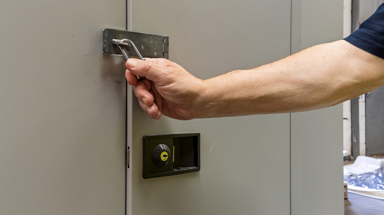 Close up of an adult male hand locking a locker in a theme park or locker room