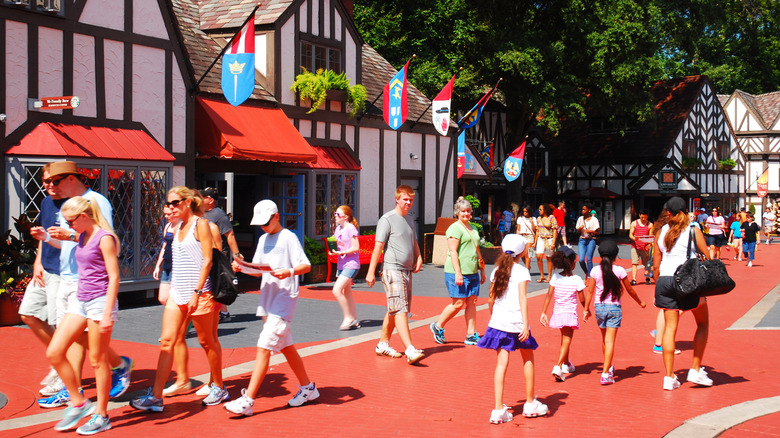 People walking through an unshaded path at Busch Gardens on a bright, sunny day