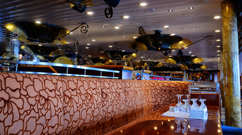 Interior of Carnival Glory dining room with brown accents and brass light fixtures