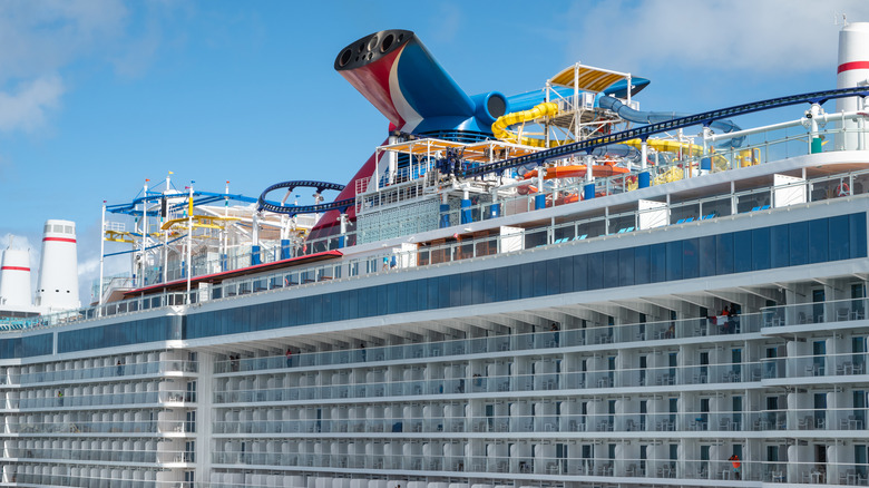 Close up, side view of Carnival Celebration with roller coaster, water park, and stateroom balconies visible while docked in port of San Juan, Puerto Rico