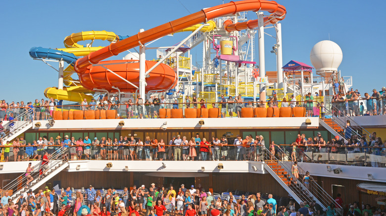 View of packed pool deck in front of water slide area on the Carnival Magic cruise ship