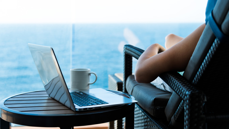 Artistic shot of woman working with a laptop on cruise ship balcony