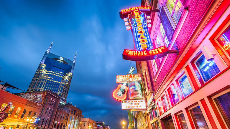 View of honky-tonks with neon signs on Lower Broadway at dusk, a district in Nashville famous for numerous country music entertainment establishments.
