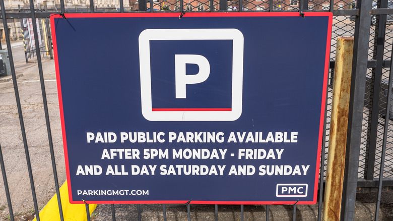 A "Paid Public Parking" sign on a metal fence in Nashville, Tennessee on a sunny winter day