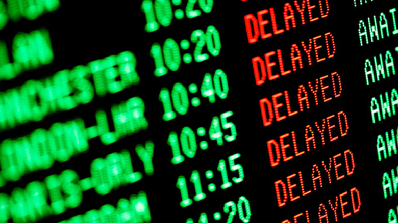Close up shot of arrivals and departures board at airport with dozens of delayed flights