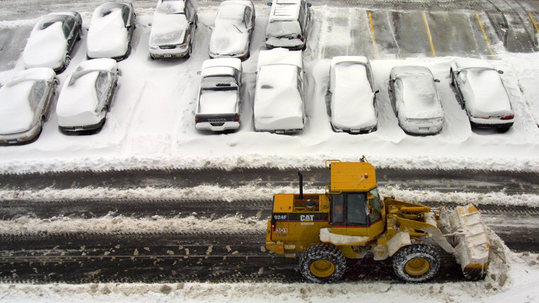 A tractor plows snow in a parking lot near the United Airlines terminal at Chicago's O'Hare International in the snow
