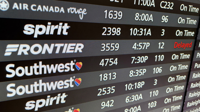 View of delayed Frontier flight on an arrivals and departures board at the airport