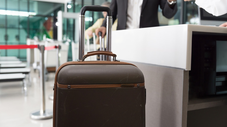 View of checked luggage sitting at the airport check in counter near scales
