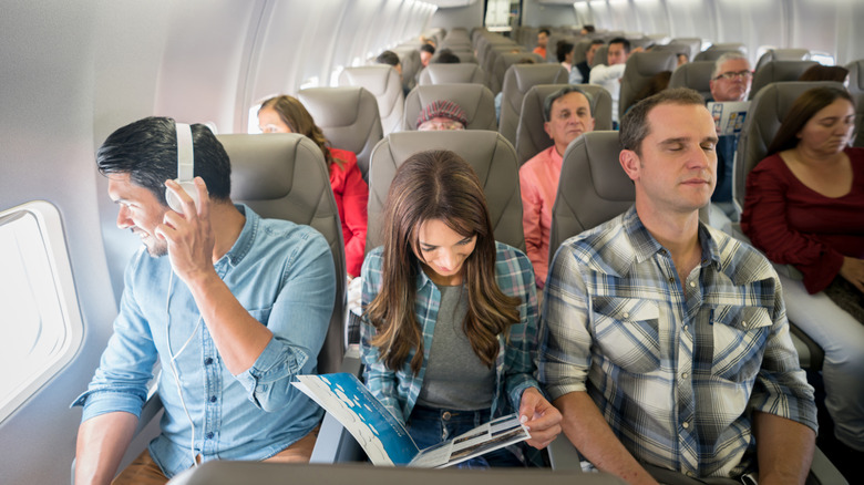 Group of travelers on an economy airline in narrow uncomfortable seats