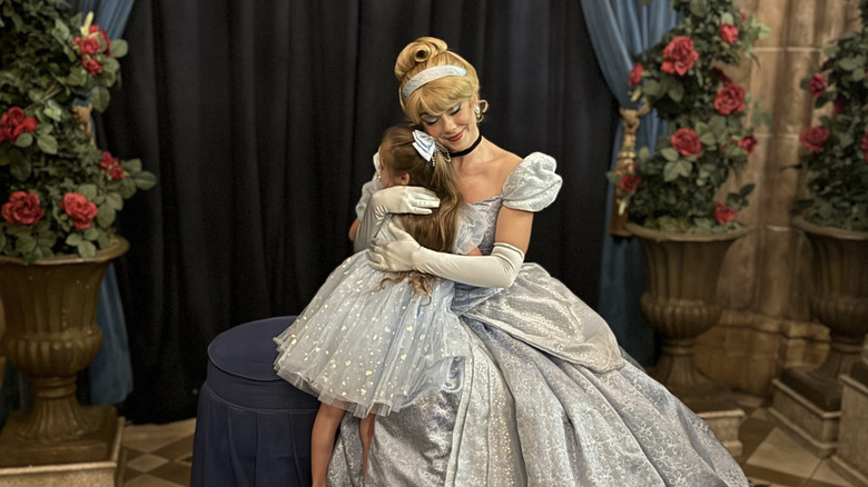 Little girl hugging Cinderella at Cinderella's Royal Table Restaurant at Magic Kingdom