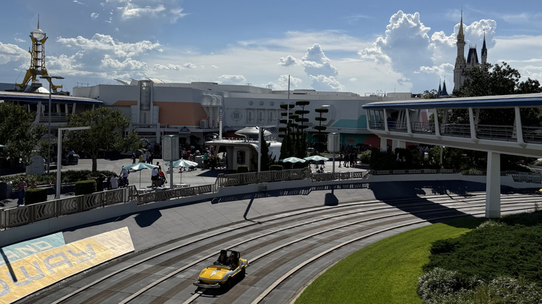 View of Tomorrowland Speedway, the PeopleMover, and other Tomorrowland rides with Cinderella Castle in the background at Magic Kingdom