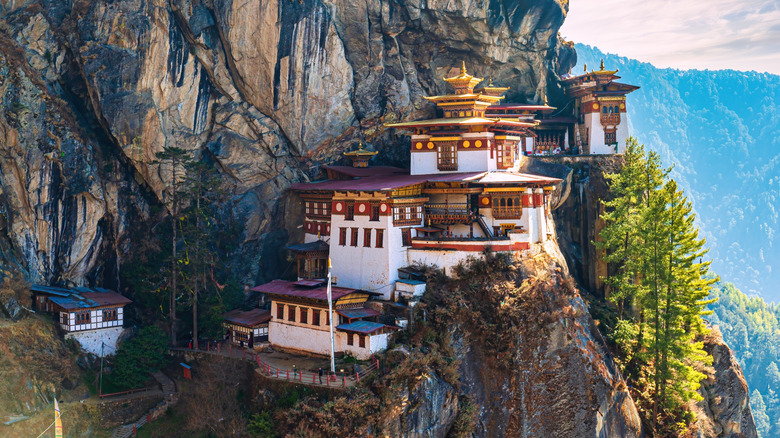 Stunning view of Taktshang Goemba Tigers Nest Monastery on a rocky hillside in Bhutan with sunlight streaming down