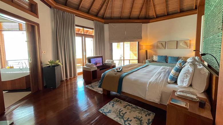 Beautiful interior design of luxurious water villa with rich teak floors, comfortable furnitur