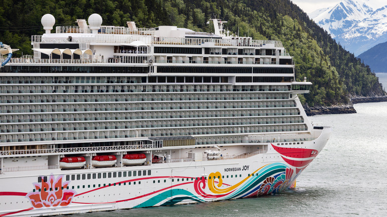 Skagway, AK, USA - June 2, 2025: The Norwegian Cruise Line Joy cruise ship at the Skagway cruise port with the Alaskan mountains in the background.