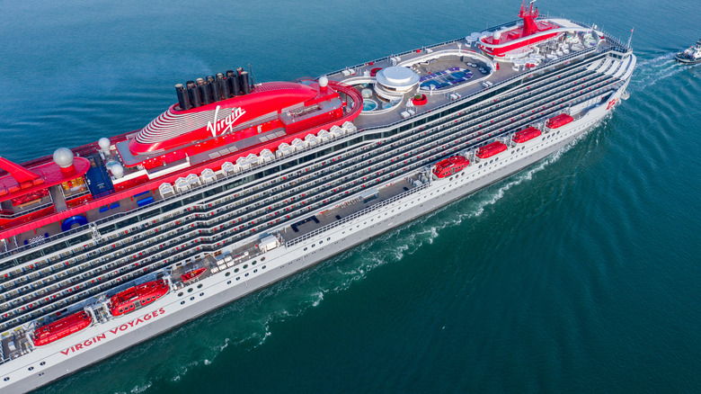 Virgin Voyages' Scarlet Lady cruise ship arriving at Portsmouth International Port on a sunny morning.