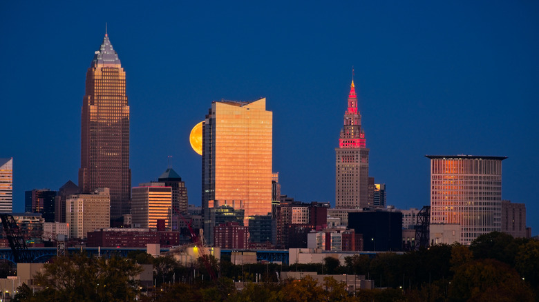 A night shot of downtown Cleveland, with a building obscuring the moon