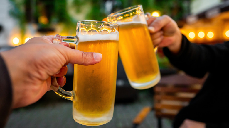 Two guys clinking beer together