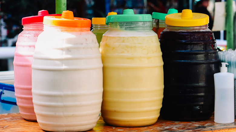 Jars of flavored water with fruit and horchata, traditional beverage in Mexico
