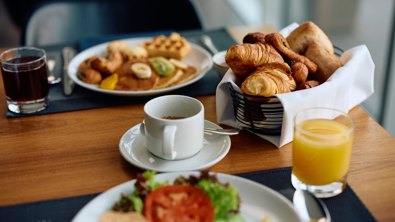 Close up of cup of coffee and buffet breakfast.