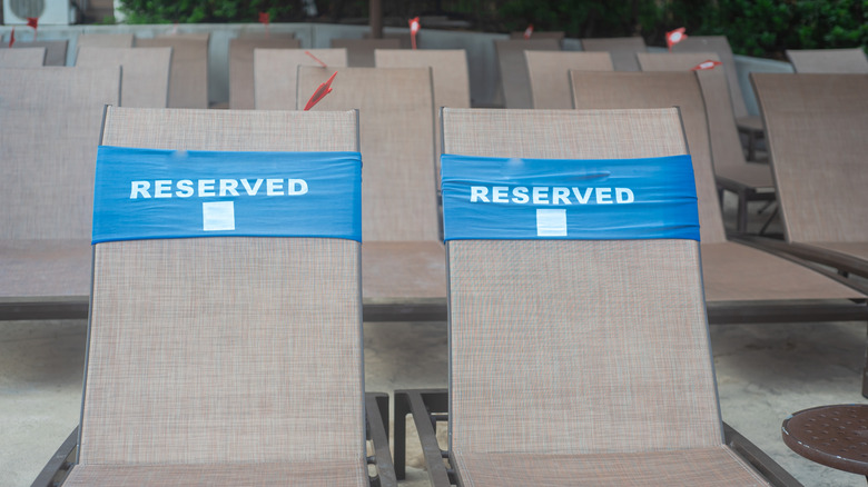 Reserved words wrap around pool lounge chairs.