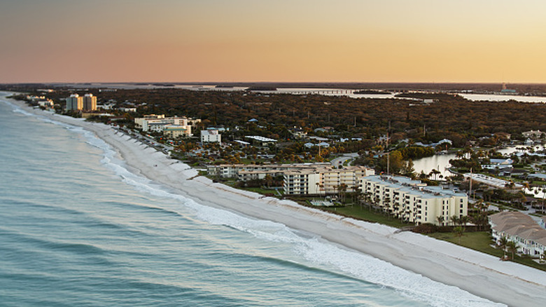 Aerial view of Vero Beach, Florida at sunset with waves hitting the shore and hotels on the beach