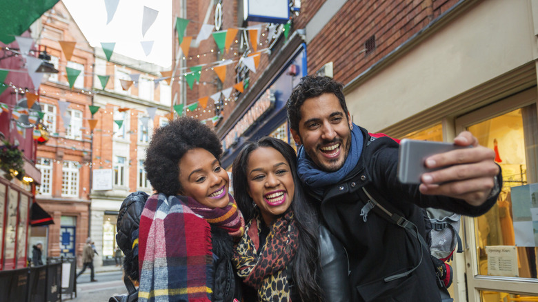 Three people take a selfie in an alley in Dublin