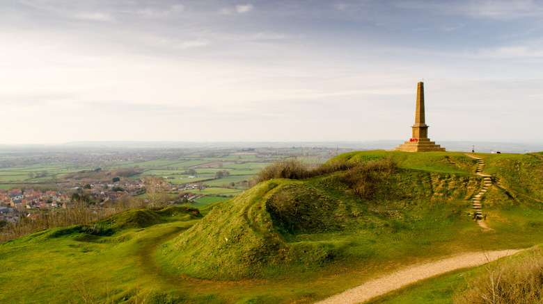 View over the Somerset Levels from Ham Hill near Yeovil, with the old quarry workings and obelisk in the foreground, Somerset, U.K.