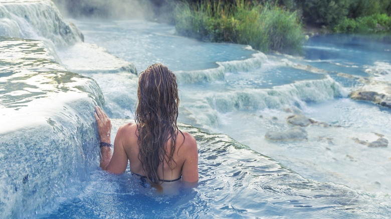 A woman relaxing in the turquoise thermal waters of Saturnia, Tuscany