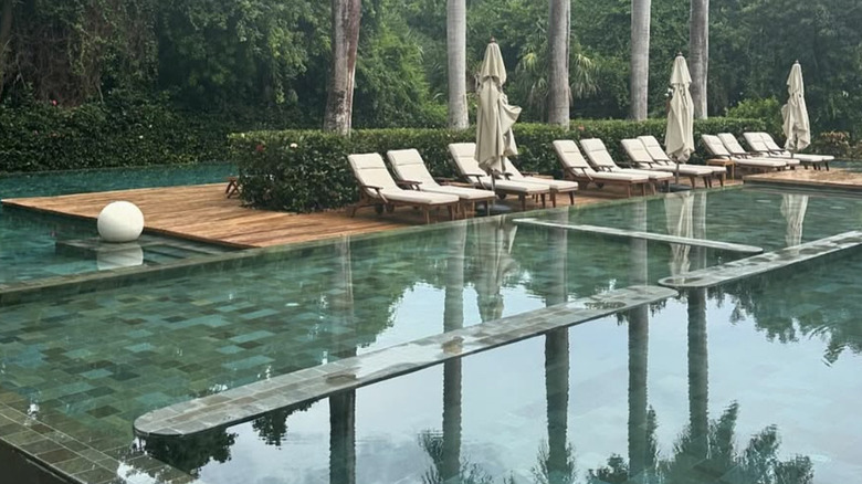 View of pool area with white lounge chairs