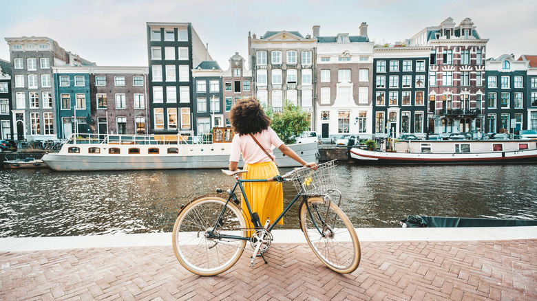 A female tourist by her bicycle in Amsterdam.
