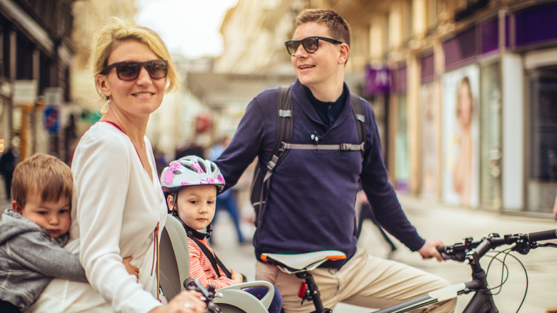 A young family enjoying a bicycle ride through a city.