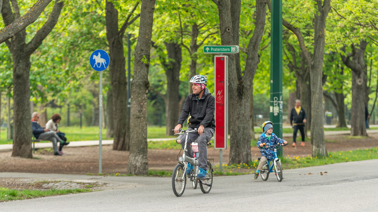 A father and child cycling in Prater Park.